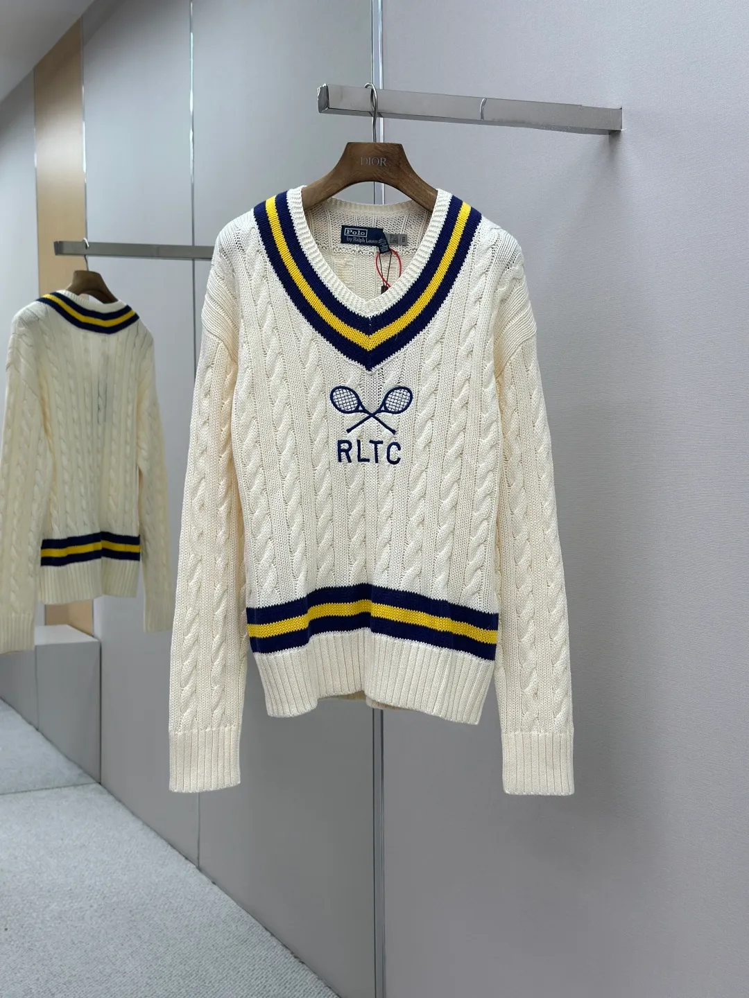 P460 Ralph Lauren Tennis Cable Knitted Sweater Made of custom-woven thick-knitted cable-knitted wool. It has a fine texture and is comfortable and close to the skin. The main color is soft cream. Pure and warm, with a sweet sense of laziness. The classic cable-knitted structure design injects soul. The V-neck is cleverly designed. The edges are outlined with navy blue and bright yellow stripes, highlighting the nobility and extraordinary. The crossed tennis racket pattern and RLTC lettering on the chest are a clever tribute to the brand's sports spirit, with an atmosphere of freedom and vitality. It is highly recognizable and interprets high-end style with unique details, painting a fascinating artistic picture. Process 1: Using imported machine embroidery technology, using advanced computer control systems and precision mechanical components to realize the embroidery work of tennis racket patterns and RLTC words with high precision and smooth and delicate lines. Process 2: Three-dimensional cable weaving. Through the clever shifting and interweaving of coils, adjacent coils are cross-shifted to form a twisting effect of cable. The lines are smooth and regular, time-consuming and labor-intensive. Process 3: Garment washing water plus soft and deodorizing process. Use professional washing equipment and specific detergents to deep clean and deodorize clothes. Improve the feel and appearance of clothes. Accessories: Customized Ralph Lauren trademark. Fit: Fitted. Size: S M L XL
